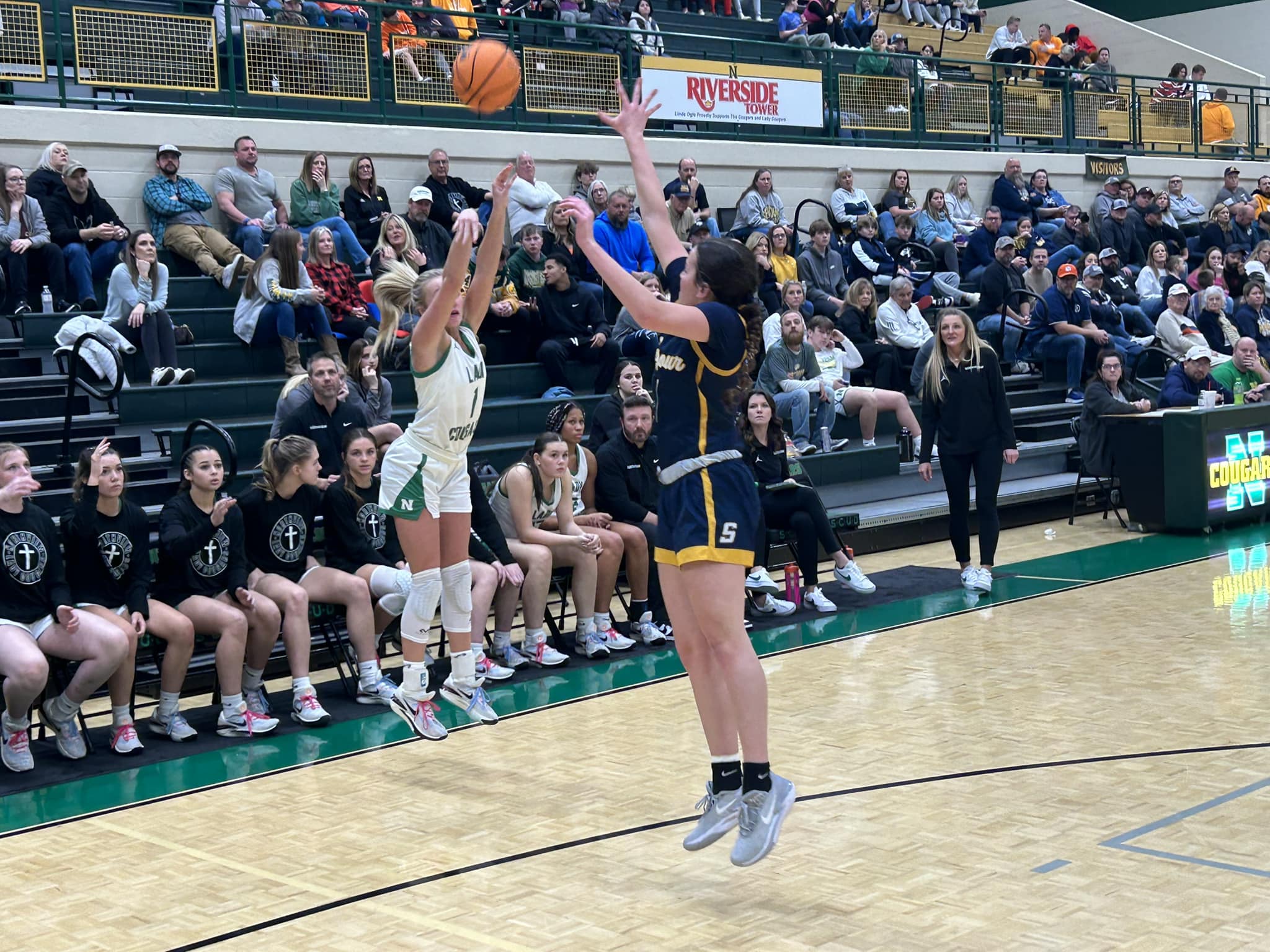 Reagan Brown (1) goes up for a three over the outstretched arms of Kali Fisher. Photo by Brian Hamilton